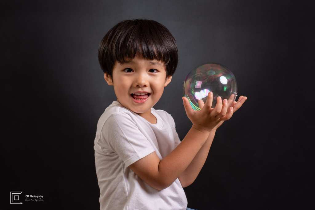 Child playing with a translucent balloon in the studio, photographed by Cristian Bucur, photographer in Bonifacio Global City.  
